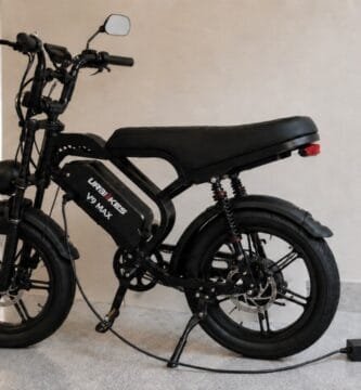 Bicicleta elétrica preta conectada ao carregador em garagem moderna