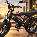 Bicicleta elétrica Inow V40 Pro 1000W preta com pneus fat, bateria removível e farol dianteiro de LED em calçadão urbano ao pôr do sol